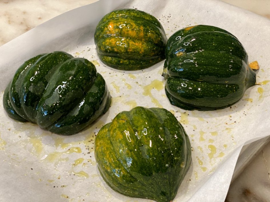 green squash on a baking sheet with olive oil on the tops
